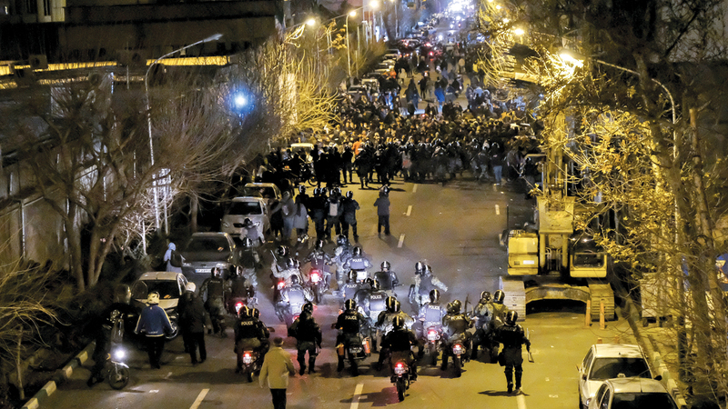 قوات الأمن الإيرانية في مواجهة المحتجين خلال 			تظاهرات في طهران. ■ أ.ب