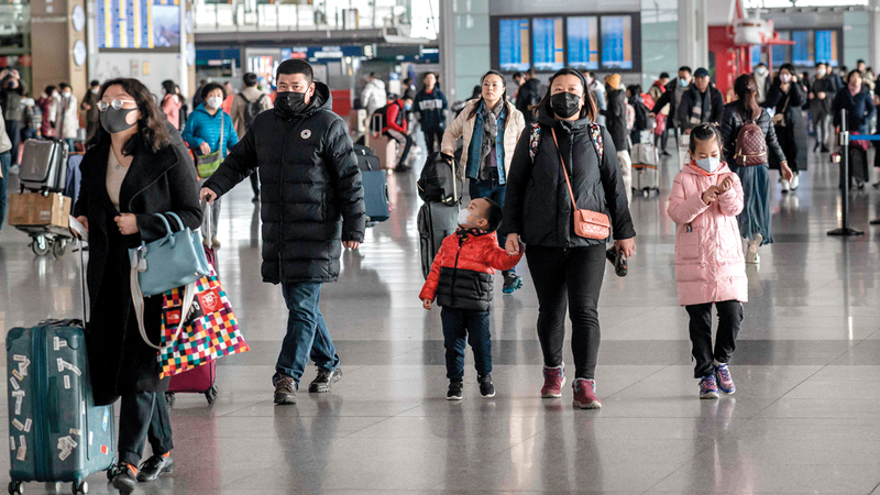 مسافرون يضعون الأقنعة الواقية في مطار بكين. أ.ف.ب