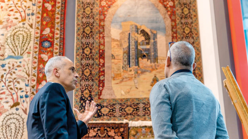 المهندس شريف حمودة يشرح تفاصيل إحدى السجادات القديمة. الإمارات اليوم