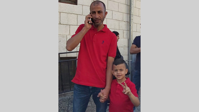 الطفل محمد عليان ووالده أثناء توجههما إلى مركز التحقيق في الشرطة الإسرائيلية. من المصدر