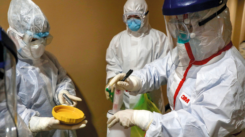 فريق طبي يجمع عينة دم للاختبار بمنطقة الحجر الصحي في ووهان الصينية التي ظهر فيها الفيروس.  أ.ف.ب