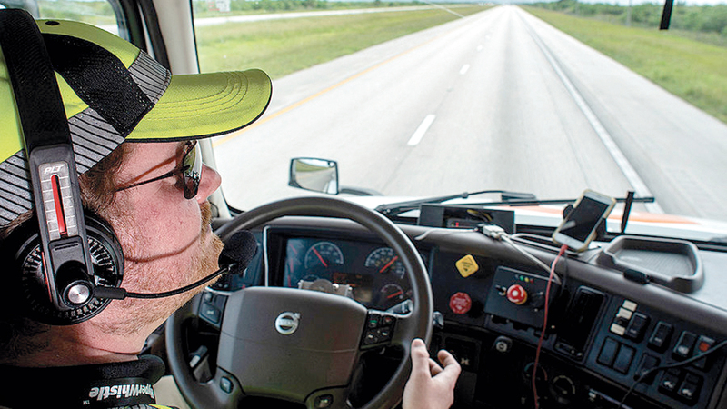 أحد سائقي الشاحنات الذاتية الحركة داخل قمرة القيادة.  من المصدر