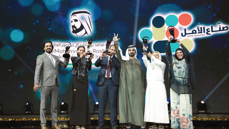 محمد بن راشد يتوسط صناع أمل فائزين في دورة سابقة. أرشيفية