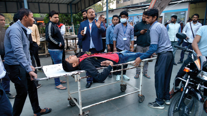 رجال الإنقاذ ينقلون أحد المصابين في الصدامات.  إي.بي.أيه