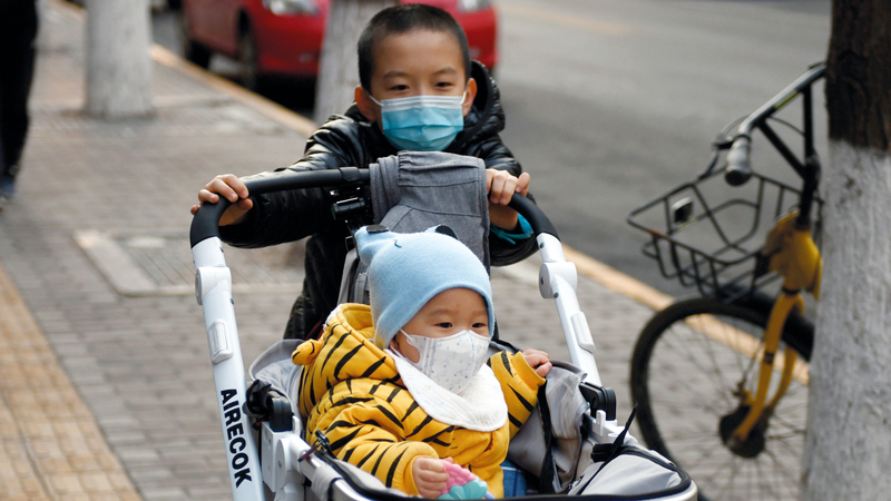طفلان يرتديان قناعين للوقاية من فيروس كورونا في بكين.  أ.ف.ب