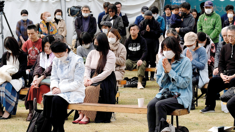 يابانيون يقفون دقيقة صمتاً إحياء لذكرى الضحايا.   أ.ف.ب