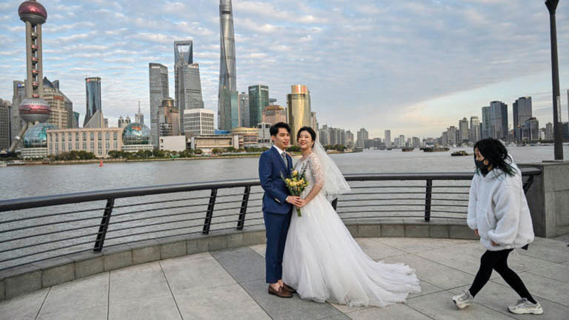 عروسان يلتقطان الصور بعيداً عن جمهور المدعوين.  أ.ف.ب