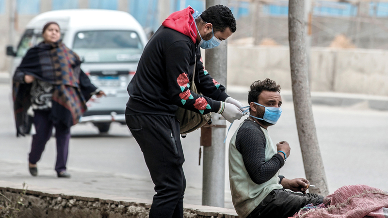متطوع يوزع كمامات في شوارع القاهرة. أ.ف.ب