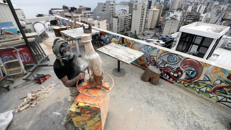 نحات ينفذ عمله الفني بالهواء الطلق.