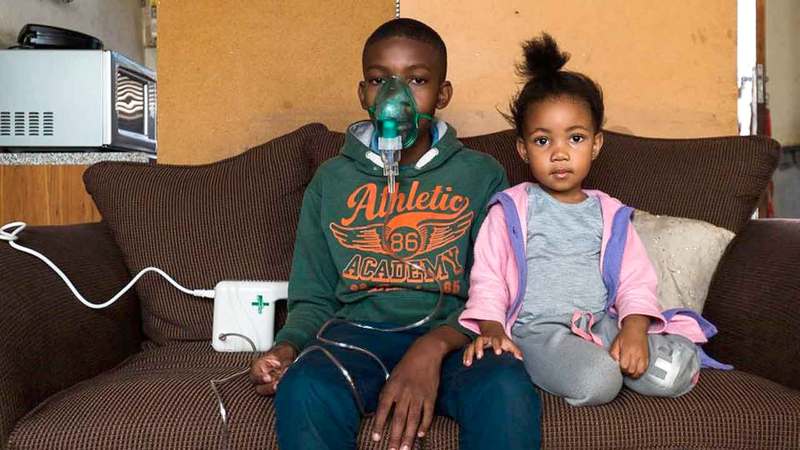 شون يجلس مع شقيقته وبجانبه جهاز التنفس الاصطناعي الذي لا يفارقه.  من المصدر