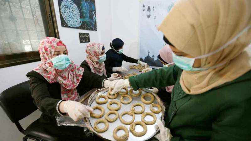 فلسطينيات يُحضّرن حلويات العيد. ■رويترز