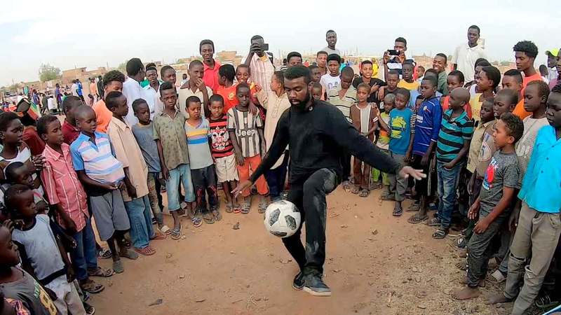 عبدالله عماد يستعرض مهارته بالكرة أمام مجموعة من الأطفال. من المصدر