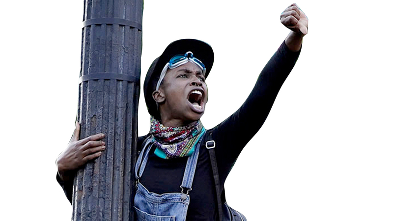 محتجة تعتلي عمود إنارة في واشنطن العاصمة.  رويترز