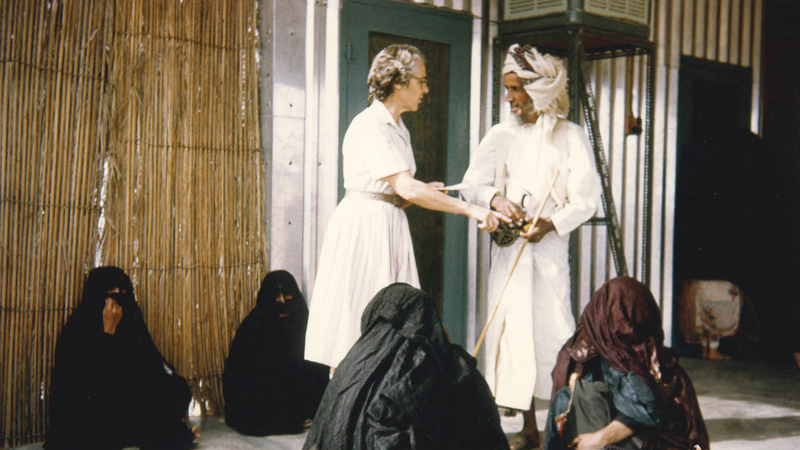 صورة لممرضة/‏‏‏‏طبيبة تتحدث مع أحد المراجعين أمام مستشفى العين في الستينات. جيردويك ديك - الأرشيف الوطني