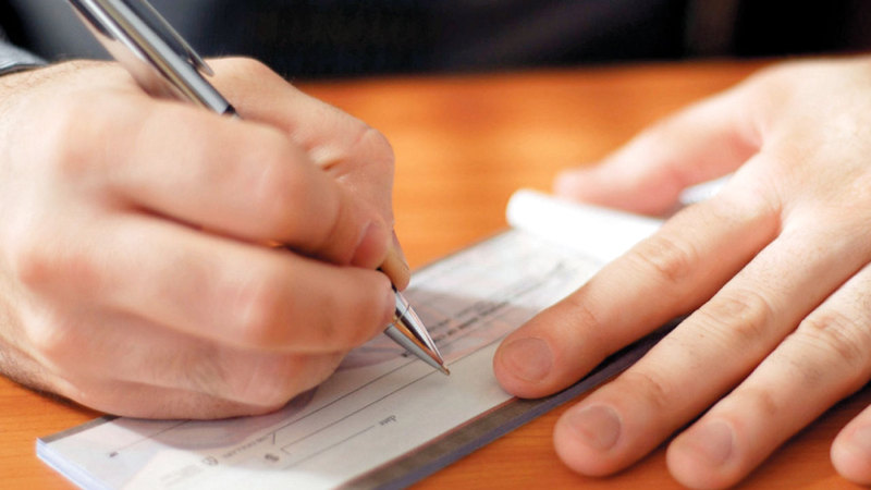 هناك نقاط جوهرية يجب مراعاتها عند كتابة الشيك أهمها ألا تُترك أي خانة فارغة فيه.  أرشيفية