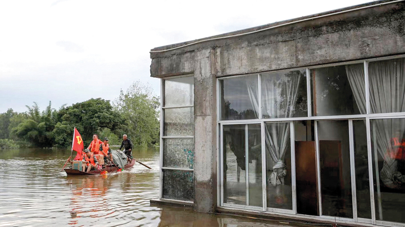 رجال الإنقاذ يعاينون الأماكن المتضررة جراء مياه الفيضان. أ.ف.ب
