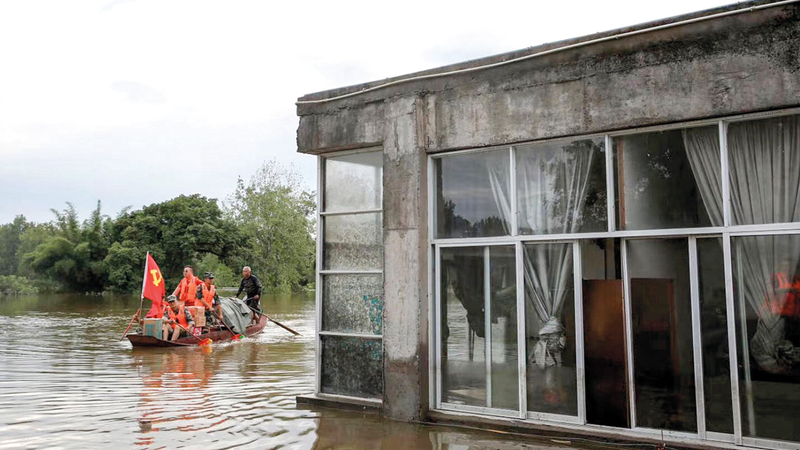 رجال الإنقاذ يعاينون الأماكن المتضررة جراء مياه الفيضان. أ.ف.ب