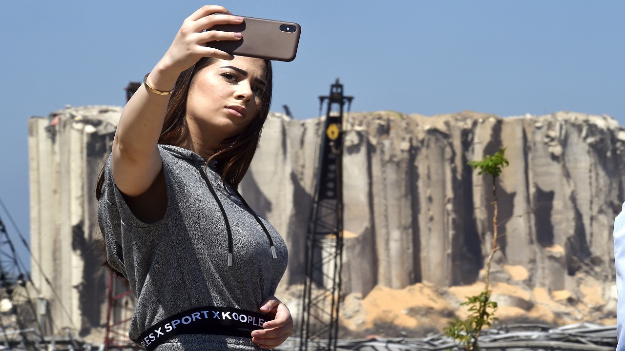 لبنانية تلتقط سيلفي بجوار موقع التفجير.