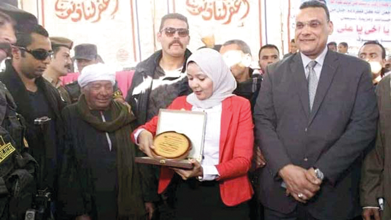 صفاء تكرم أحد أولياء الدم بـ«درع التسامح».  من المصدر
