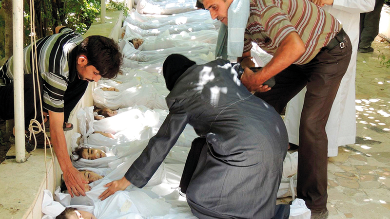 أم سورية تبحث عن أطفالها وسط الضحايا من الأطفال الذين تعرضوا لهجوم كيماوي في الغوطة. أ.ف.ب