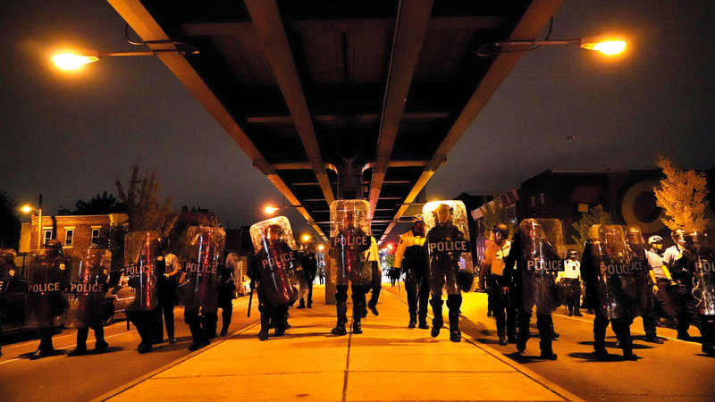 رجال الشرطة يصنعون متراساً في مواجهة تقدم المتظاهرين الغاضبين.   أ.ب