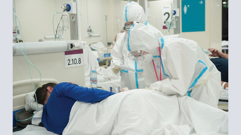 أخصائيون طبيون يعتنون بمريض كورونا في مستشفى مؤقت بمركز تسوق في موسكو. ■رويترز