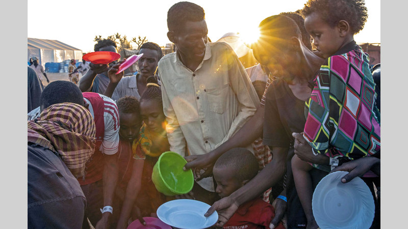 لاجئون إثيوبيون ينتظرون وجبة طعام في مخيم أم راكوبة في القضارف.   أ.ب