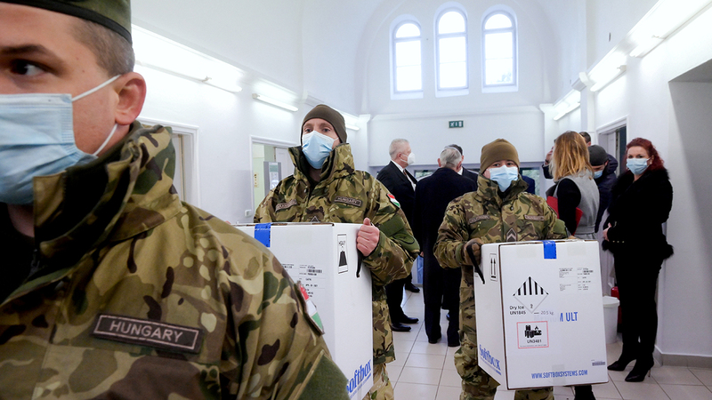 جنود مجريون يحملون أول شحنة من لقاحات فيروس كورونا أمس. رويترز