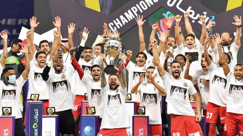 نجم شباب الأهلي كارتابيا يرفع كأس السوبر وسط فرحة عارمة من لاعبي شباب الأهلي. تصوير: أسامة أبوغانم