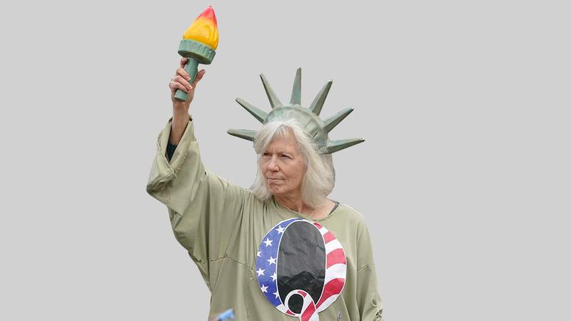 امرأة تتقمص شخصية تمثال الحرية ترتدي قميص حركة كيو أنون خلال تظاهرة في كولمبيا في السادس من يناير 2021.  أ.ب