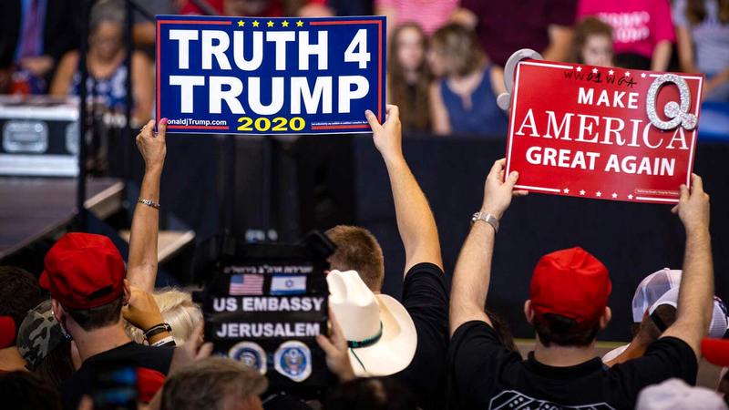 مؤيدون لترامب يرفعون لافتات كُتبت عليها شعاراته.  غيتي