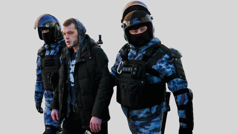 شرطيان يعتقلان أحد المتظاهرين.  أ.ب