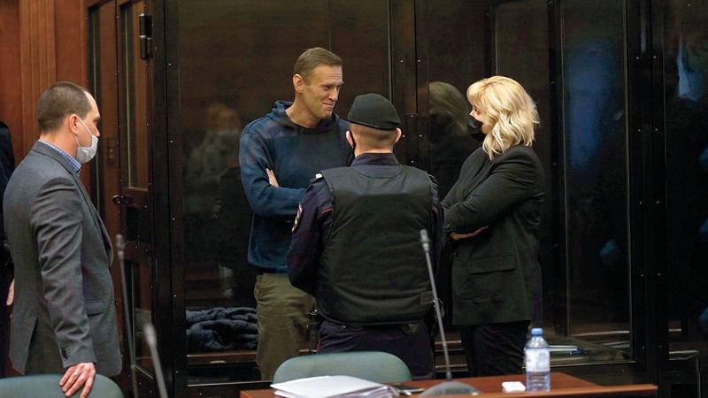 نافالني يتحدث إلى أحد محاميه خلال جلسة الاستماع لأقواله.  أ.ب