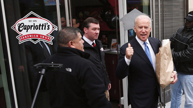 بايدن يحمل كيساً يحتوي على سندويتشات.  غيتي