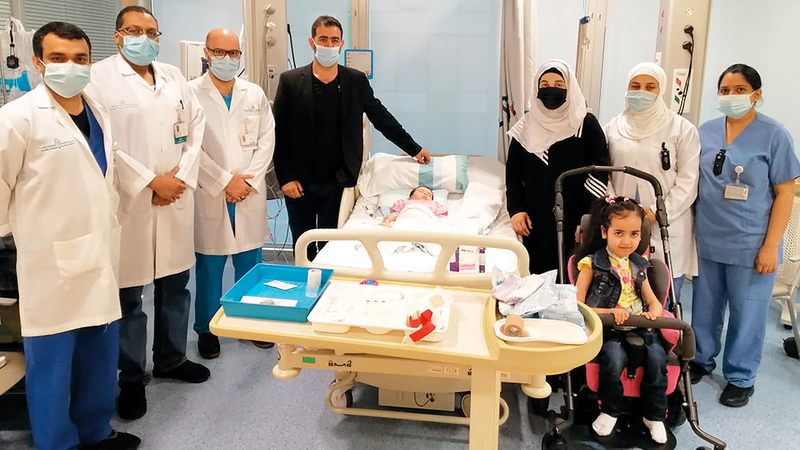 «منيرة» مع الفريق الطبي وأسرتها.. وتظهر أختها في الصورة مريضة بالمرض نفسه.  من المصدر