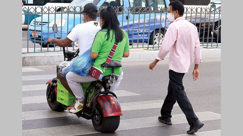 شاب يستخدم الدرّاجة في توصيل راكبة. تصوير: إريك أرازاس