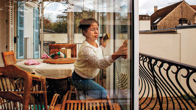 جينا تنظف نوافذ بيت مخدومها في باريس.	   من المصدر