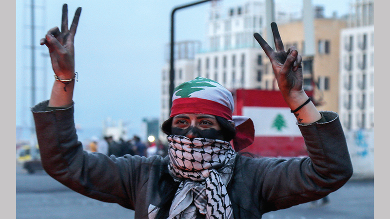 إحدى المتظاهرات ترفع علامة النصر في بيروت. إي بي.إيه
