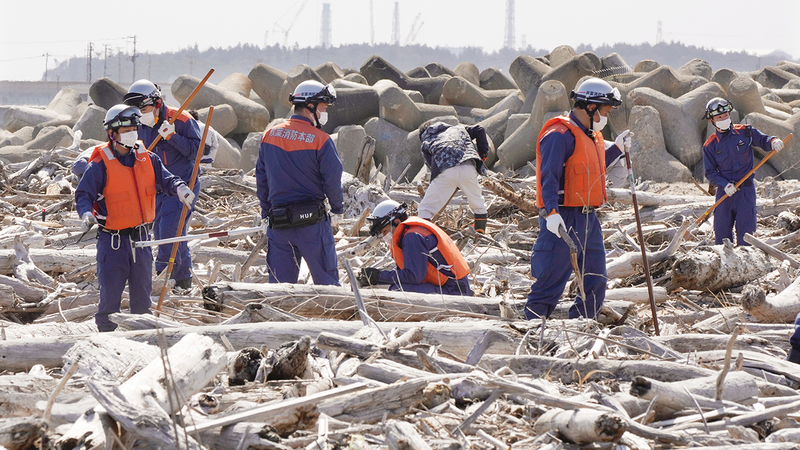 رجال الدفاع المدني يجرون عمليات بحث عن رفات المفقودين.  إي.بي.إيه