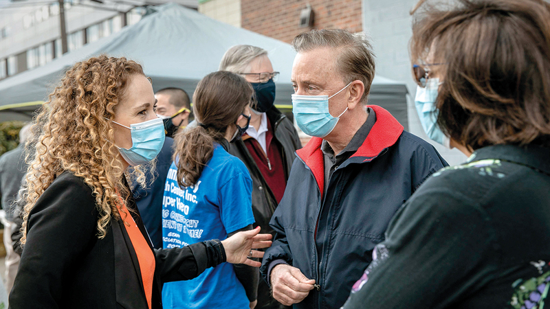 حاكم ولاية كونيكتيكيت نيد لامونت «في الوسط» لدى زيارته مركز للمهاجرين القادمين إلى أميركا.   أ.ف.ب