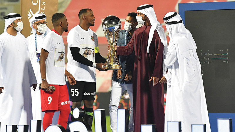 راشد بن حميد يسلّم كأس الخليج العربي إلى قائد شباب الأهلي ماجد ناصر. À الإمارات اليوم