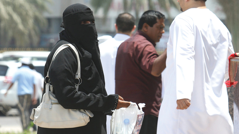 متسولة تحاول استعطاف المارة.   أرشيفية