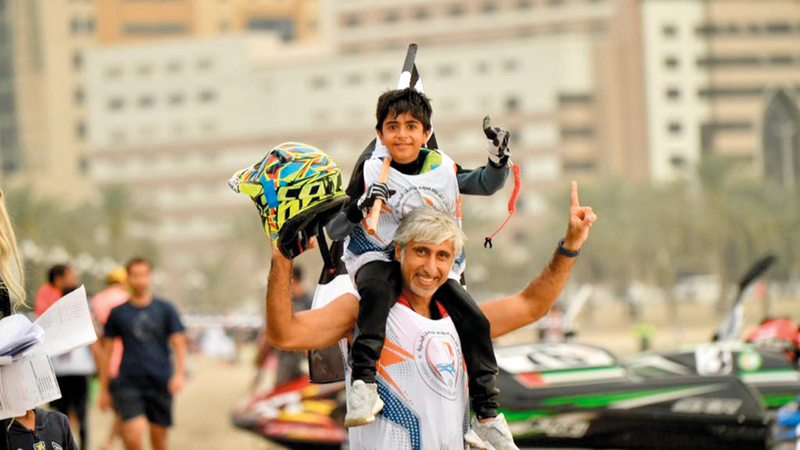 علي مع والده بعد الفوز بأحد سباقات الدراجات المائية.  من المصدر