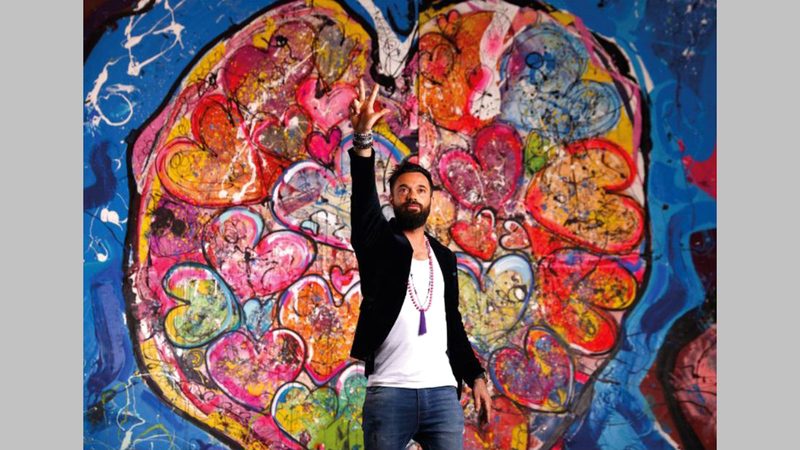 الرسام العالمي ساشا جفري يقدم عرضاً حياً في المزاد.   وام