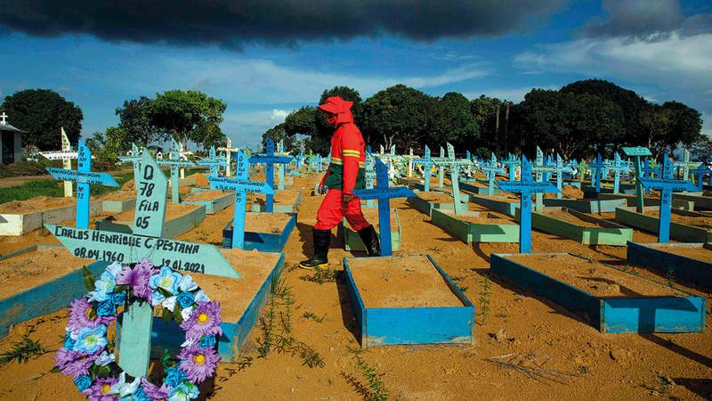 حفار قبور يمشي بين قبور ضحايا جائحة «كورونا» في البرازيل نتيجة سوء تعامل بولسونارو مع هذه الأزمة.  أ.ف.ب