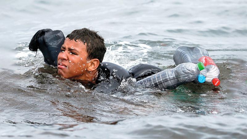 صبي مغربي يغامر سباحة مستخدماً زجاجات الماء كقارب في طريقه بحراً إلى سبتة. رويترز