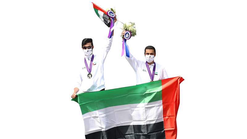 سالم ملهوف ومنصور الفارسي يرفعان علم الإمارات على منصة التتويج.   من المصدر