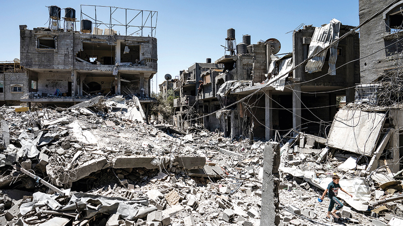 طفل يسير بين أنقاض مبنى دمرته غارة إسرائيلية على غزة.   أ.ب