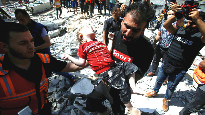 رجال الدفاع المدني يستخرجون فتاة فلسطينية متوفاة من تحت انقاض المبنى الذي انهار بسبب عنف الغارات الإسرائيلية.   رويترز