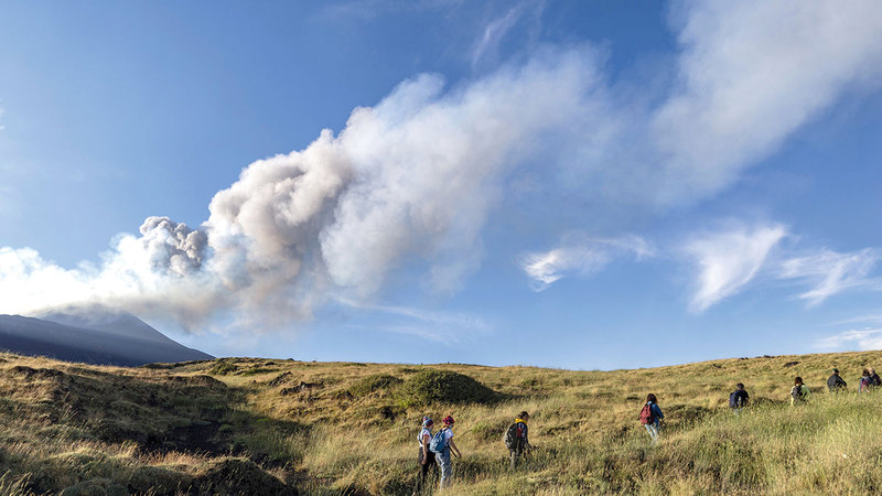 متسلقون يسيرون قبالة البركان الذي عاود الانفجار.  أ.ب